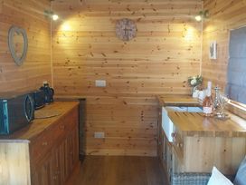 A kitchen with wooden cabinets and appliances at The Damselfly in Bewholme near Hornsea