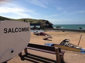 A beach with boats and a vehicle at 24 The Salcombe in Salcombe
