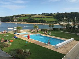 An outdoor swimming pool with people enjoying at 24 The Salcombe in Salcombe