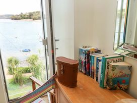 A table with books and a suitcase overlooking the water at 24 The Salcombe Salcombe