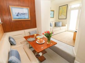 A dining room with a table and seating at 24 The Salcombe in Salcombe