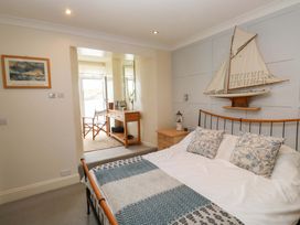 A bedroom with a bed and adjoining seating area at 24 The Salcombe in Salcombe