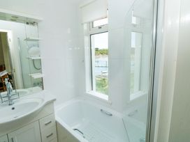 A bathroom with a bathtub and sink at 24 The Salcombe in Salcombe