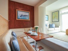 A dining area with a table and couch at 24 The Salcombe in Salcombe