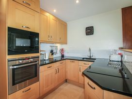 A kitchen with cabinets, appliances and a sink at 24 The Salcombe in Salcombe
