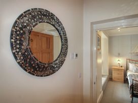 A bedroom with a mirror and furniture at 24 The Salcombe in Salcombe