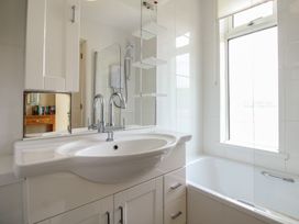 A bathroom with a sink and bathtub at 24 The Salcombe in Salcombe