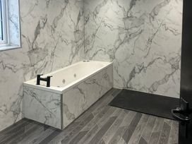 A bathroom with a bathtub and window at Sugar loft in Silloth