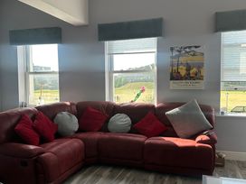 A living room with a red sofa and cushions at Sugar loft in Silloth