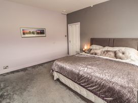 A bedroom with a bed and wall art at Sugar Loft in Silloth