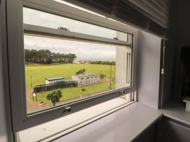 A view from a window showing a park with grass and trees at Sugar Loft in Silloth