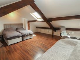 A bedroom with two beds and a chair at Sugar Loft in Silloth