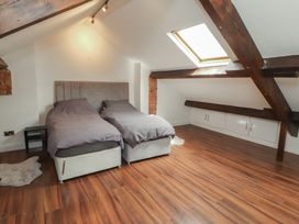 A bedroom with two beds and a skylight at Sugar Loft in Silloth