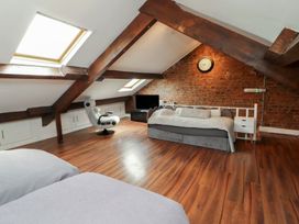 An attic with a bed and sofa at Sugar Loft in Silloth