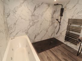 A bathroom with a bathtub and shower at Sugar Loft in Silloth
