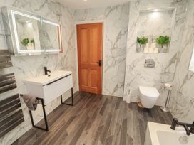 A bathroom with sink, toilet, and storage at Sugar Loft in Silloth