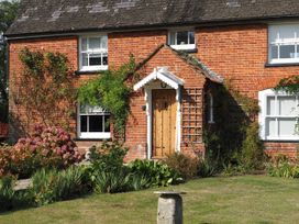 A brick house with a flower bed at Cutbush Farmhouse in Norwich