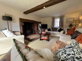 A living room with sofas and a television at Cutbush Farmhouse in Norwich