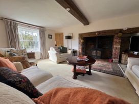 A living room with a fireplace and sofa at Cutbush Farmhouse in Norwich