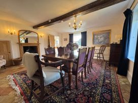 A dining room with a large table and chairs at Cutbush Farmhouse in Norwich