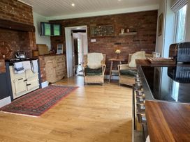 A kitchen with stove and seating area at Cutbush Farmhouse in Norwich