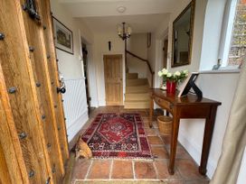 A hallway with a table and flowers at Cutbush Farmhouse in Norwich