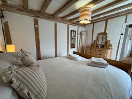 A bedroom with a bed and a dresser at Cutbush Farmhouse in Norwich