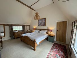 A bedroom with a bed and furniture at Cutbush Farmhouse in Norwich