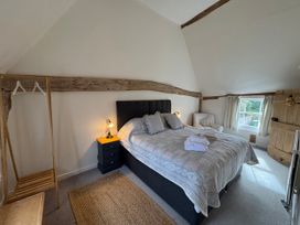 A bedroom with a bed and nightstand at Cutbush Farmhouse in Norwich