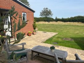 A patio area with chairs and a table at Cutbush Farmhouse in Norwich