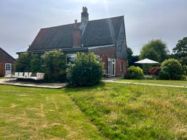 An outdoor area with a house and seating at Cutbush Farmhouse, Norwich