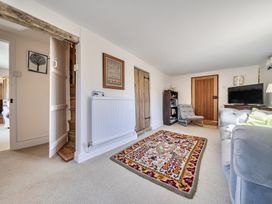 A living room with a rug and television at Cutbush Farmhouse in Hingham