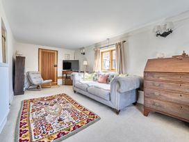 A living room with a sofa and a rug at Cutbush Farmhouse in Hingham
