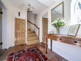 A hallway with a staircase and a table at Cutbush Farmhouse in Hingham