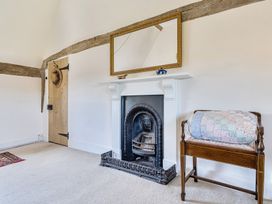 A living room with a fireplace and a mirror at Cutbush Farmhouse in Hingham