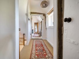 A hallway with carpet and lighting at Cutbush Farmhouse in Hingham