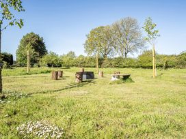 An outdoor area with logs and trees at Cutbush Farmhouse in Hingham