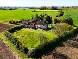 An outdoor view of a farmhouse surrounded by fields at Cutbush Farmhouse in Hingham