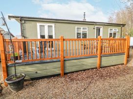 A house with a wooden fence and gravel area at The Nest Lodge 55 Grantham