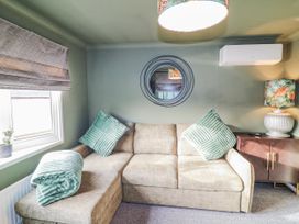 A snug with a sofa and plant at The Nest Lodge 55 Grantham