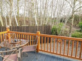 An outdoor patio with a table and chairs at The Nest Lodge 55 Grantham