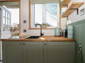 A kitchen with sink and stove at Salt Haven Shepards Hut Pevensey