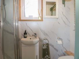 A bathroom with a sink and shower at Salt Haven Shepards Hut Pevensey