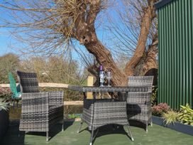 An outdoor seating area with a table and chairs at Salt Haven Shepards Hut Pevensey