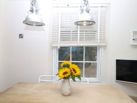 A dining room with a vase of flowers on a table at Dennings House, Mayors Avenue in Dartmouth