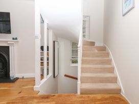 A staircase and hallway with a mirror and fireplace at Dennings House, Mayors Avenue Dartmouth