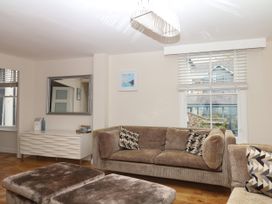 A living room with a sofa and large mirror at Dennings House, Mayors Avenue in Dartmouth