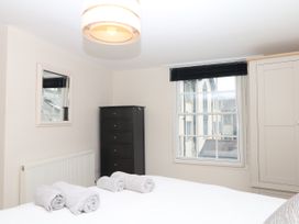 A bedroom with a bed, towels, and a chest of drawers at Dennings House, Mayors Avenue, Dartmouth