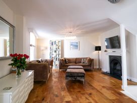 A living room with a sofa and bookshelves at Dennings House, Mayors Avenue, Dartmouth