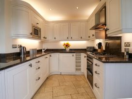 A kitchen with cupboards, stove, and microwave at Dennings House, Mayors Avenue in Dartmouth